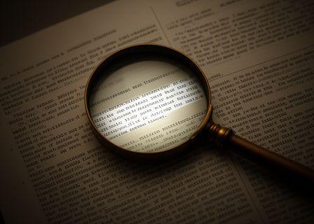 A magnifying glass over complex fine print text